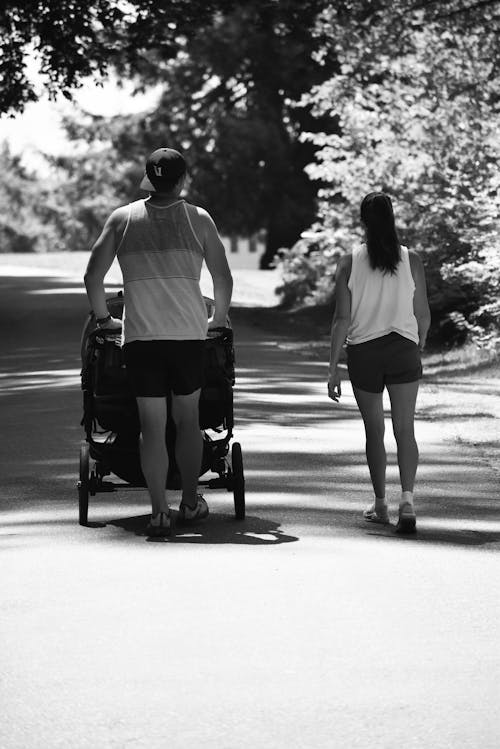 Woman and Man Walking with Stroller in Park