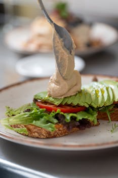 A delicious open-face sandwich with fresh veggies and creamy hummus.