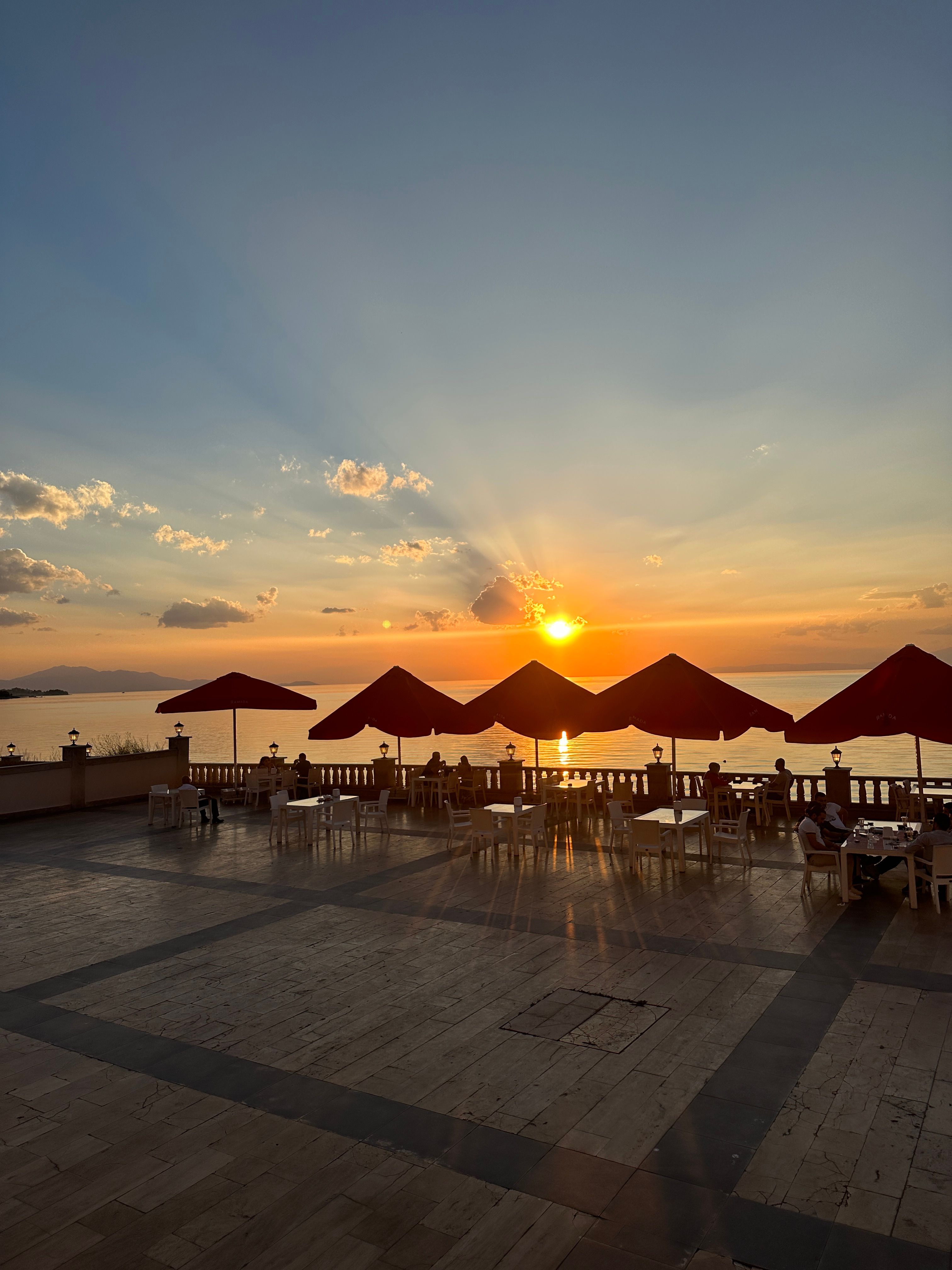 Seminyak beach club terrace in Bali in December with a clearing afternoon storm and golden light over the ocean