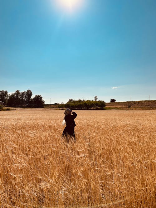 Woman Standing on Sunlit, Rural Field