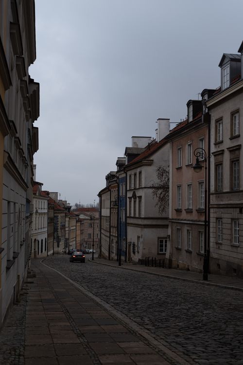 Free Picturesque cobblestone street in European town with classic architecture on a cloudy day. Stock Photo