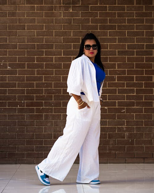 Young Woman in a Fashionable Outfit Standing on the Sidewalk in City 