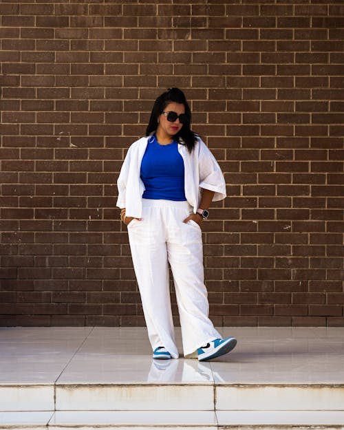 Young Woman in a Fashionable Outfit Standing on the Sidewalk in City 