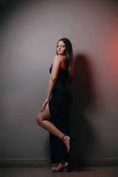 Sophisticated pose of a woman in a black dress, perfect for fashion and portrait themed content.