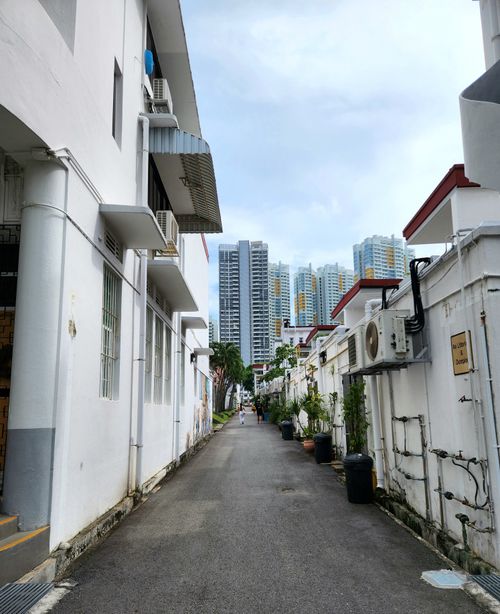 Free A narrow alleyway in Tiong Bahru with skyscrapers in the distance. Stock Photo