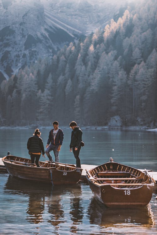 Men And A Woman Standing On Brown Boat