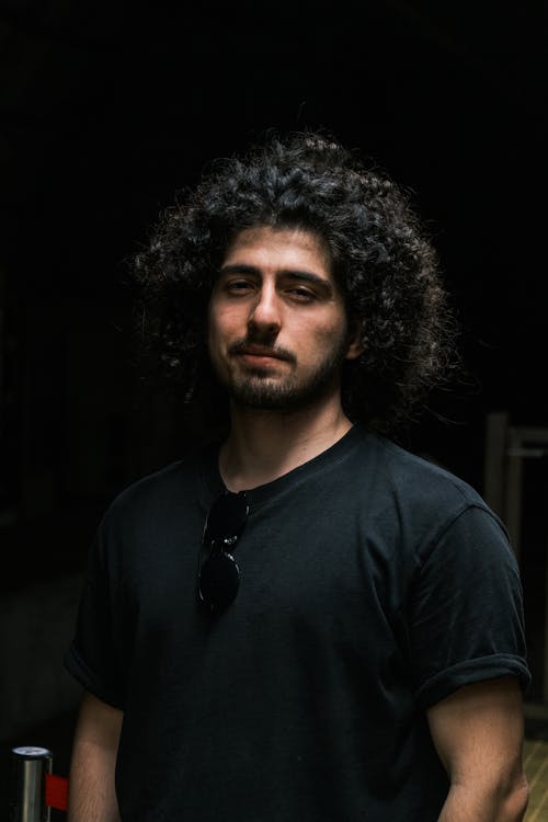 Studio Shot of a Young Man with Long Curly Hair and a Black T-shirt 