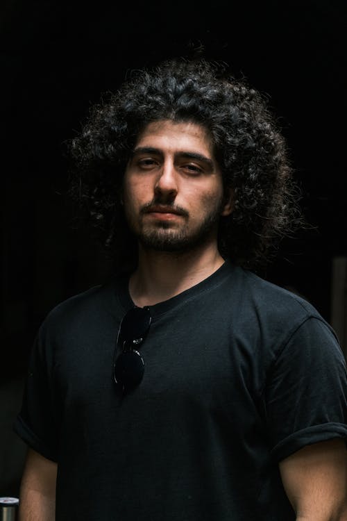 Studio Shot of a Young Man with Long Curly Hair and a Black T-shirt 