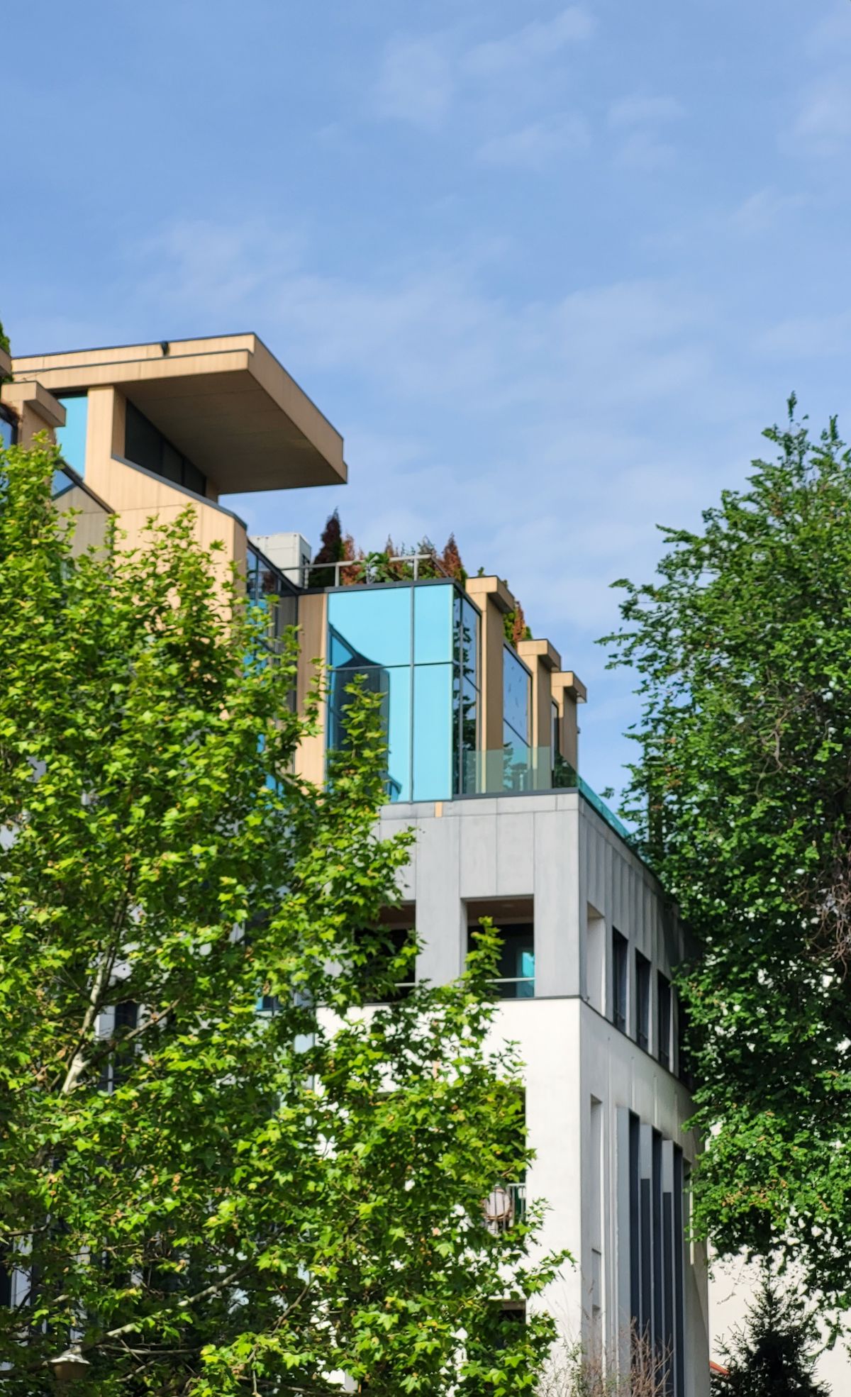 A modern building with rooftop vegetation and glass facades