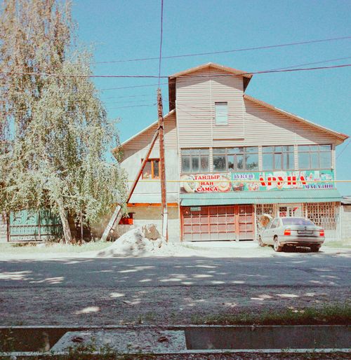 Free Street view of a small business building in Talgar, Kazakhstan with car and tree. Stock Photo