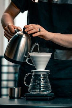 Close-up of a barista in Adana preparing coffee using pour-over technique.