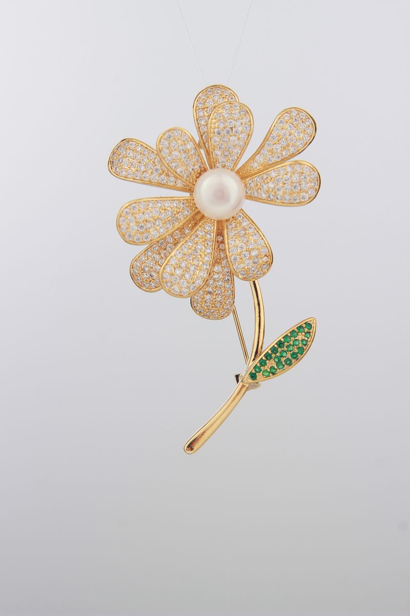 Golden flower-shaped brooch with gemstones