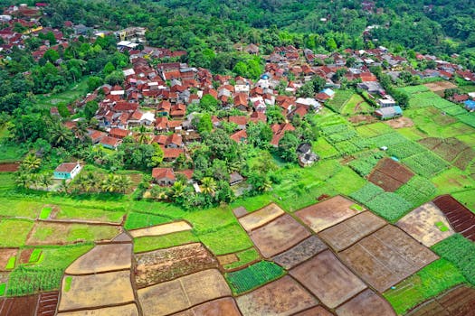 Aerial shot of Parung Kuda, West Java, showing lush greenery, village, and terraced fields.