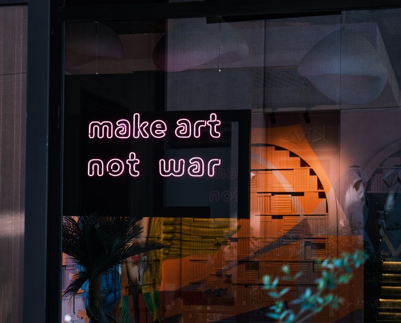 A neon sign conveys a powerful anti-war message in an urban art setting. A neon sign conveys a powerful anti-war message in an urban art setting.