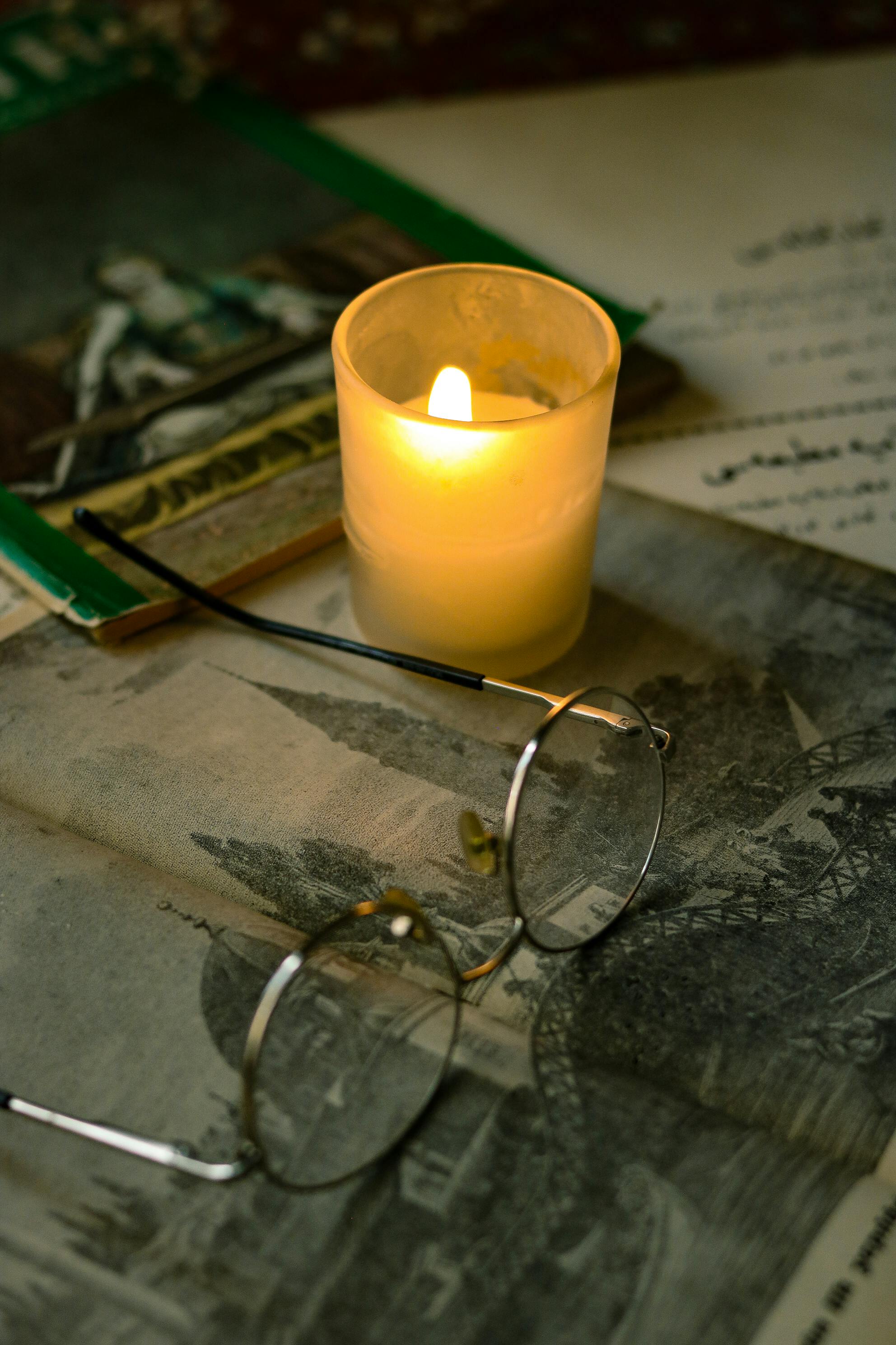 Eyeglasses and a Lit Candle · Free Stock Photo
