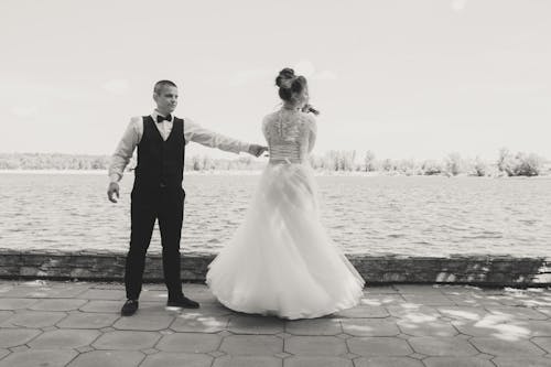 Black and White Photo of Newlyweds Dancing by the Lake 