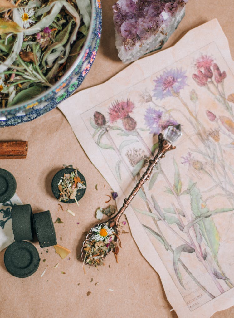 Bowl And A Spoon Of Dried Herbs On A Drawing Of Wildflowers