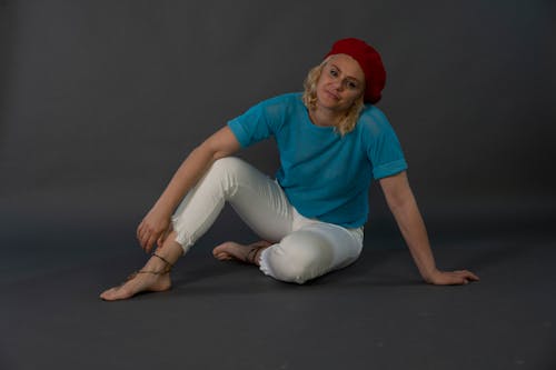 Blonde Woman in Hat and Blue T-shirt Sitting