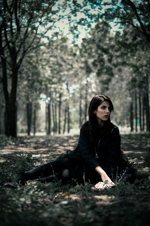 Free Woman in black attire sitting in a serene park in Islamabad, Pakistan. Stock Photo