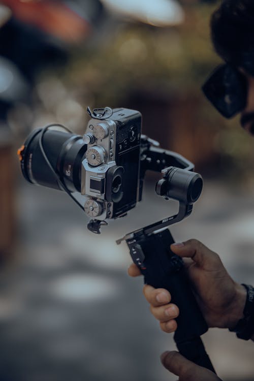 Hand Holding Camera on Tripod