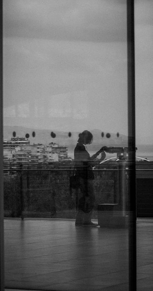 Free Reflection of a Woman and Modern Buildings in a Large Window  Stock Photo