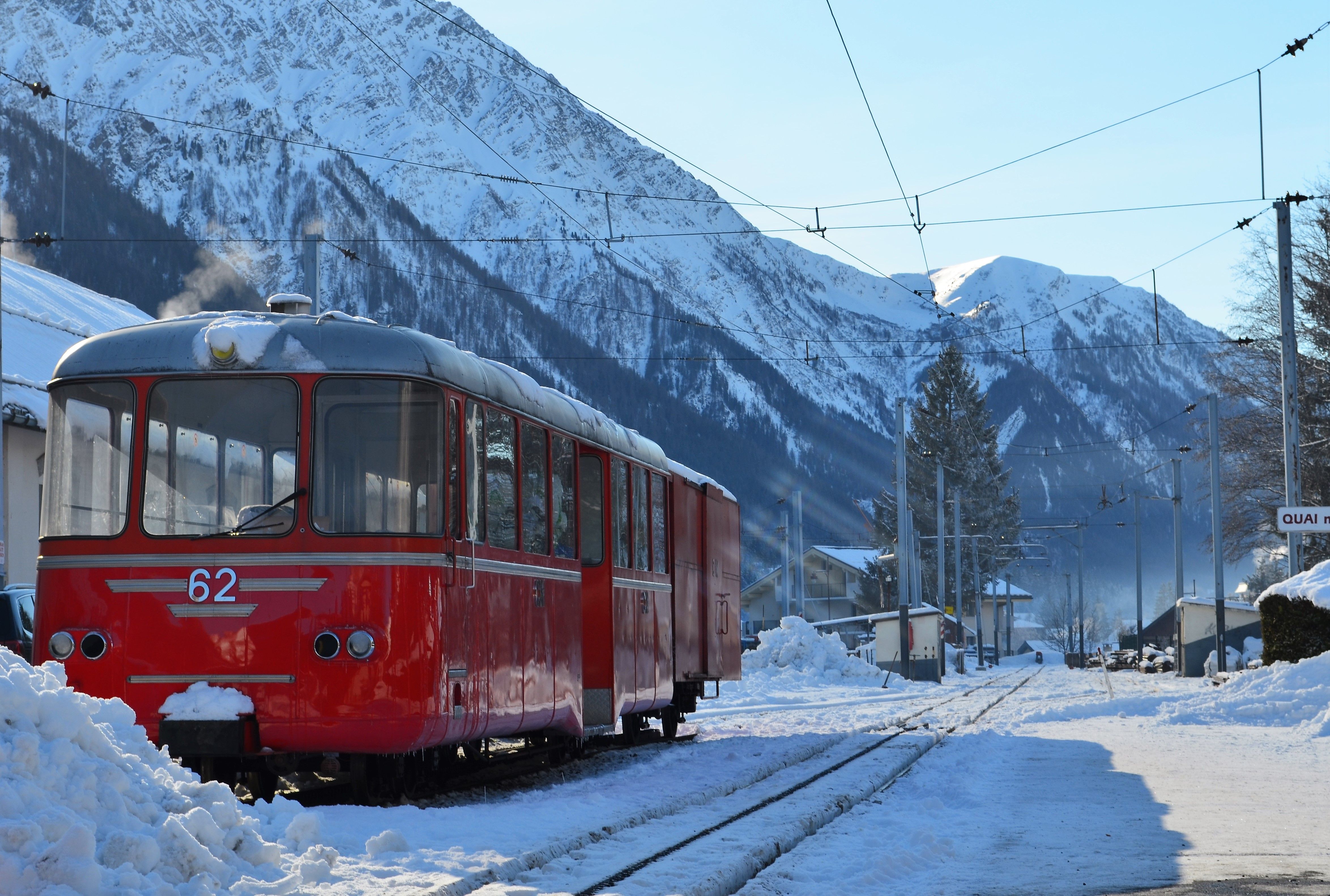 Red train in snowy Chamonix-Mont-Blanc, showcasing winter travel in the French Alps.