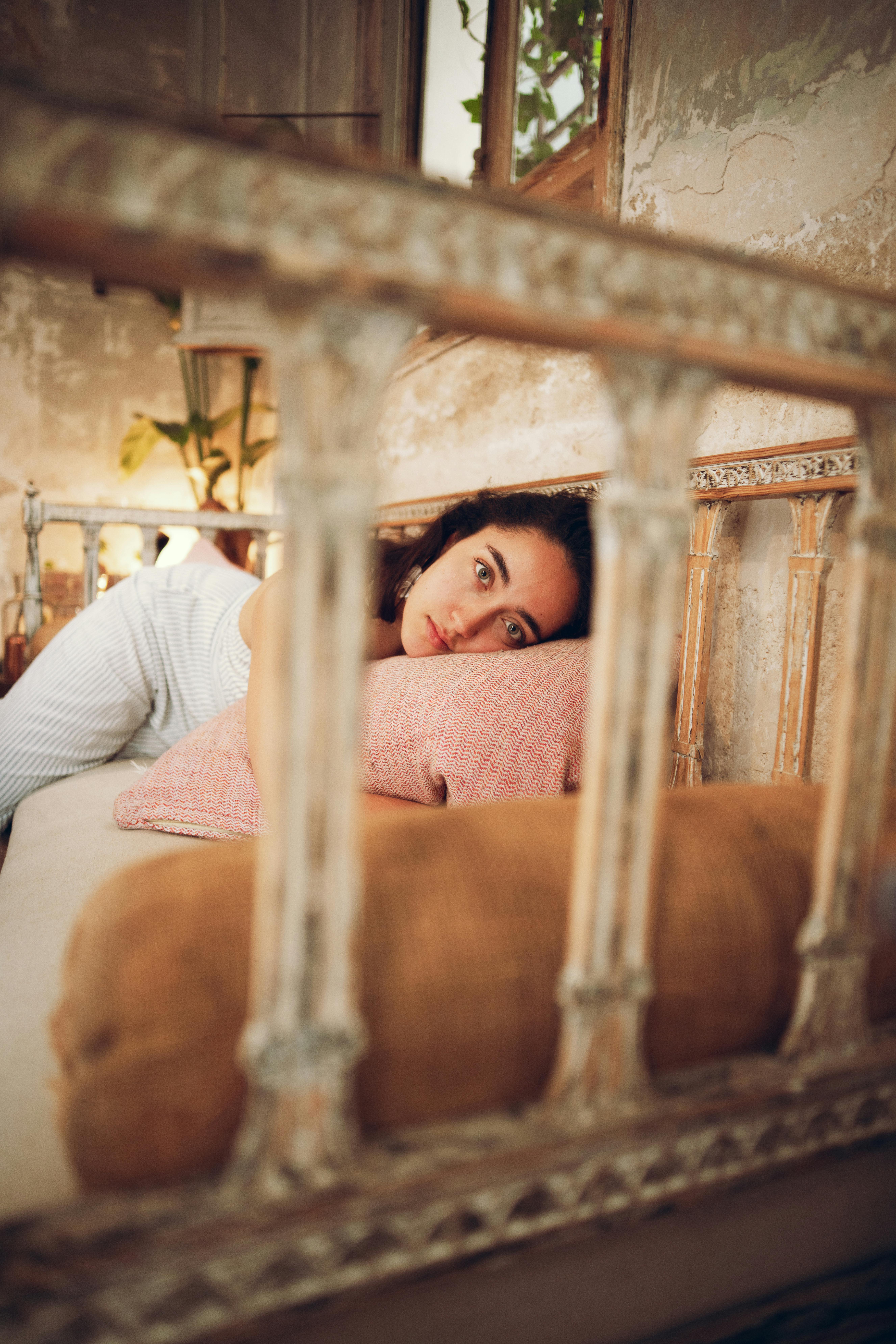 A woman lies comfortably in a vintage-style bedroom, creating a warm and intimate atmosphere.