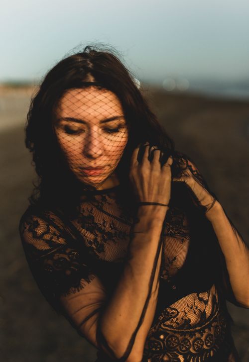 Free Dramatic portrait of a woman in lace and veil, evoking mystery and elegance outdoors. Stock Photo