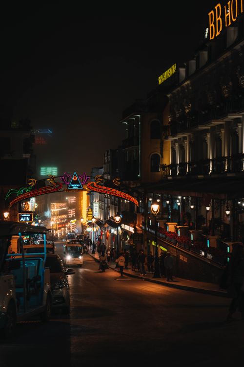 Free Bustling city street at night featuring colorful neon lights and lively ambience. Stock Photo