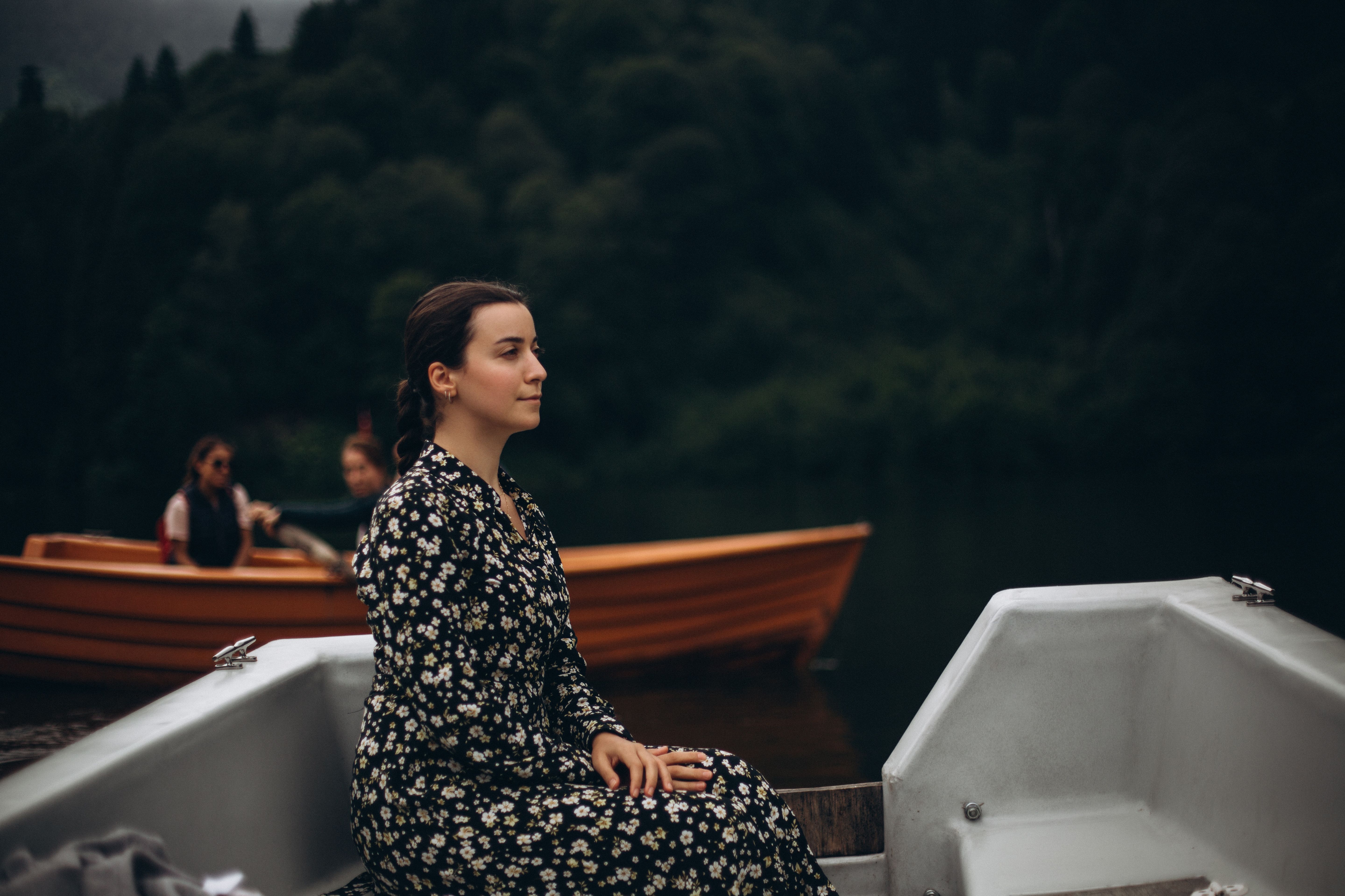 A woman sitting in a boat on a lake · Free Stock Photo