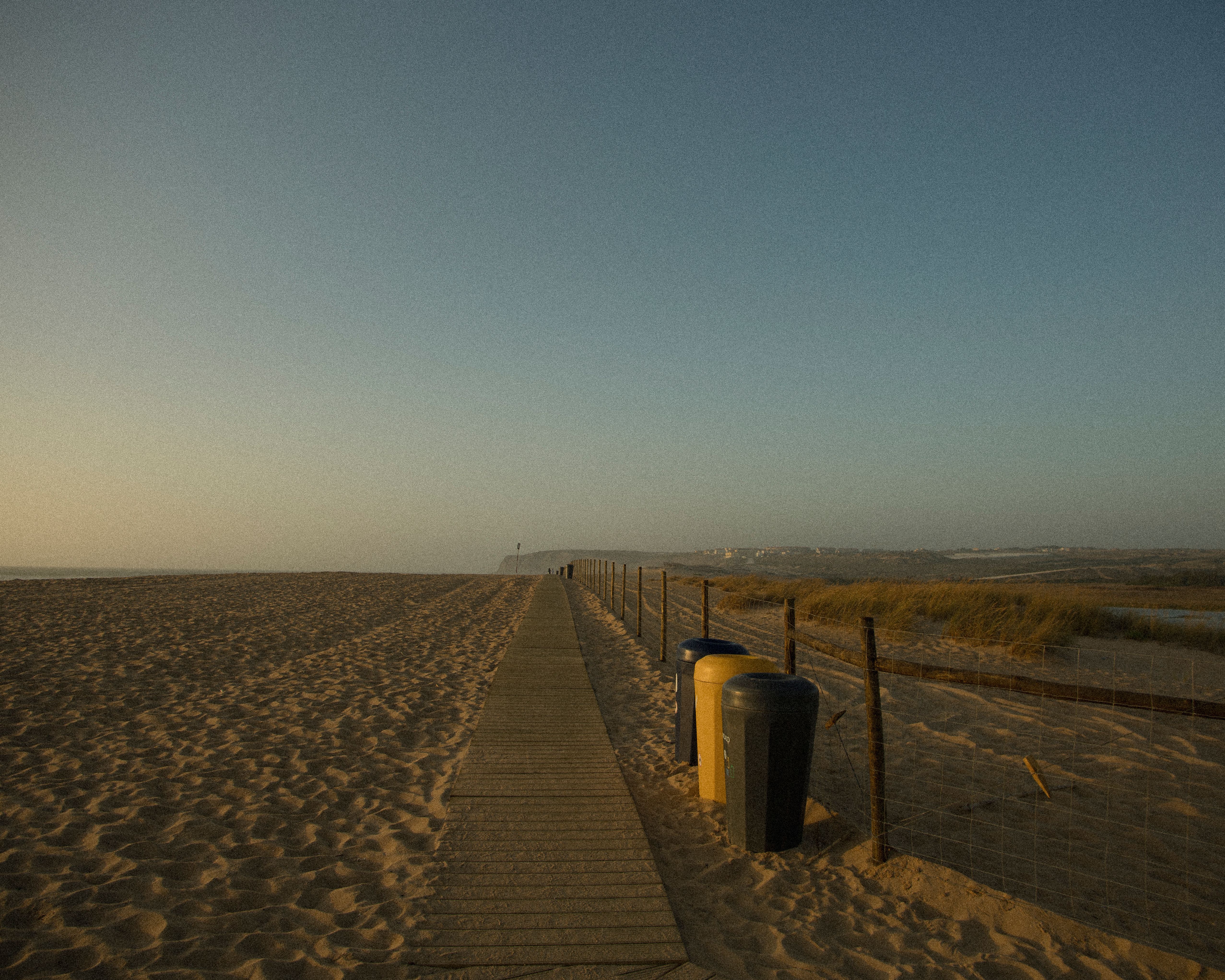 Long open sands of Costa da Caparica with beach bars and dunes stretching south