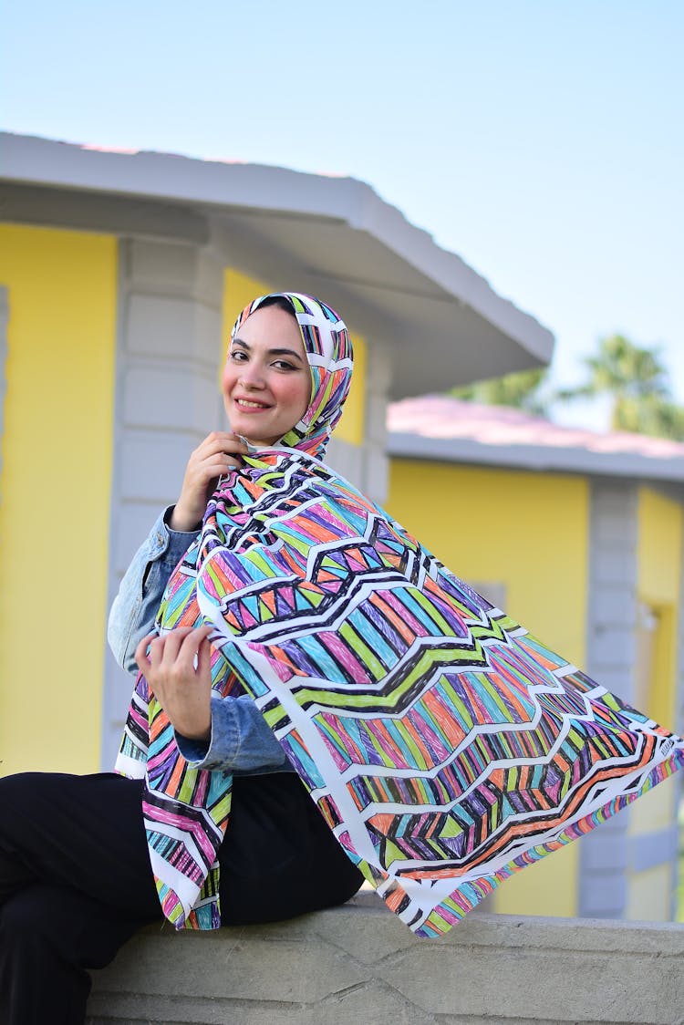 Smiling Woman In Headwear Sitting Outdoors