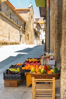 Colorful fruits on display at a traditional outdoor market in Guimarães, Portugal.