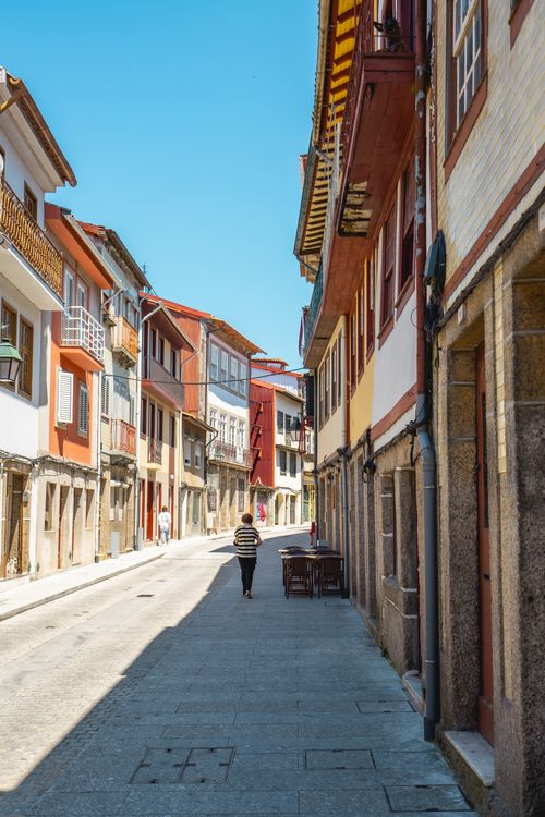 Free Sunny day view of a charming, historic street in Guimarães, Portugal with colorful architecture. Stock Photo