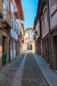 Discover the historic charm of a cobblestone street in Guimarães, Portugal. Ideal for travel enthusiasts.