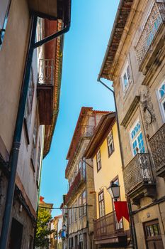 Explore a picturesque narrow street surrounded by historic buildings in Guimarães, Portugal.