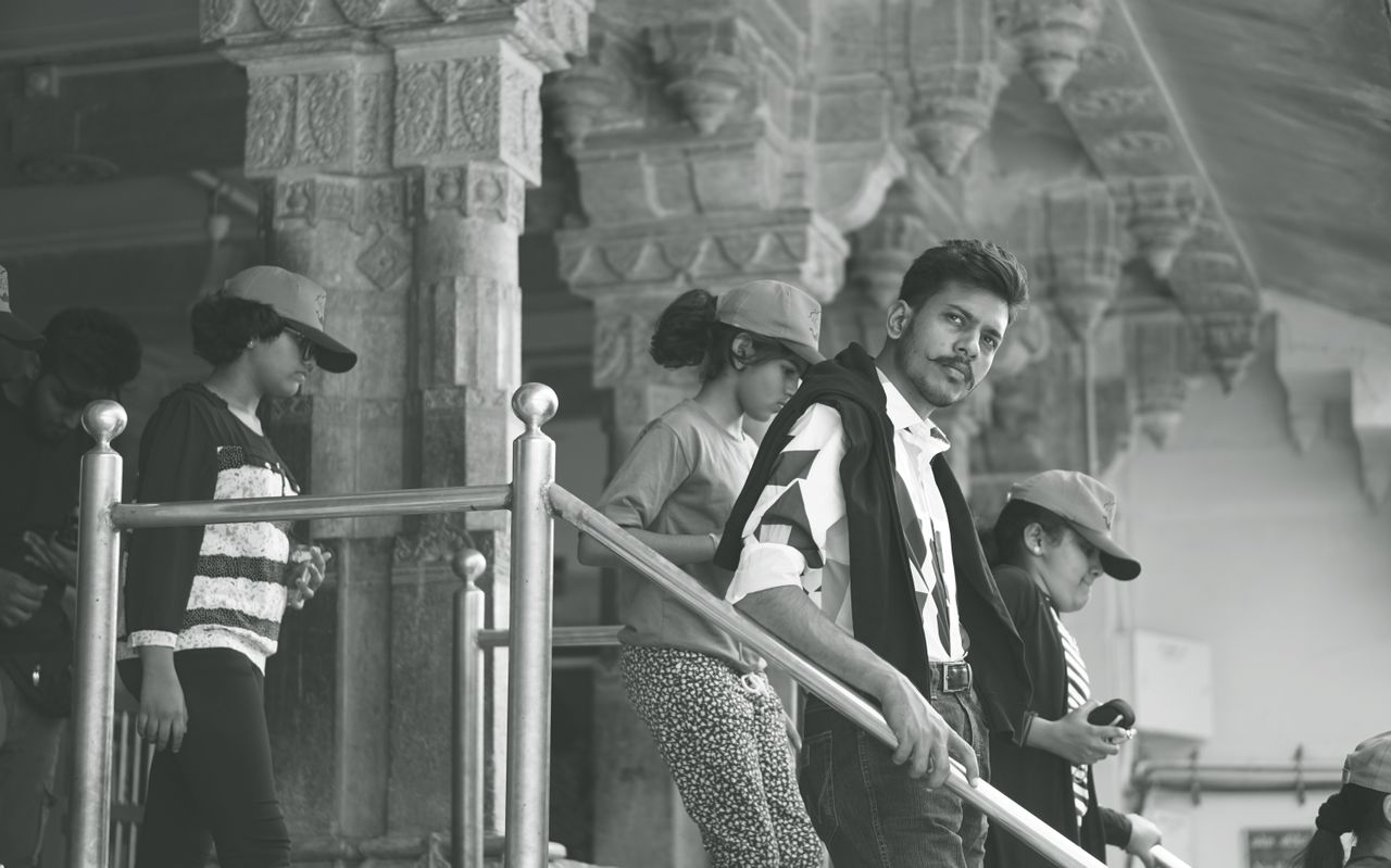 black and white photo of tourists in a historic indian palace with int