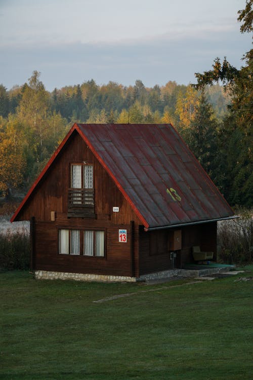Wooden Cottage with Number on Facade by River