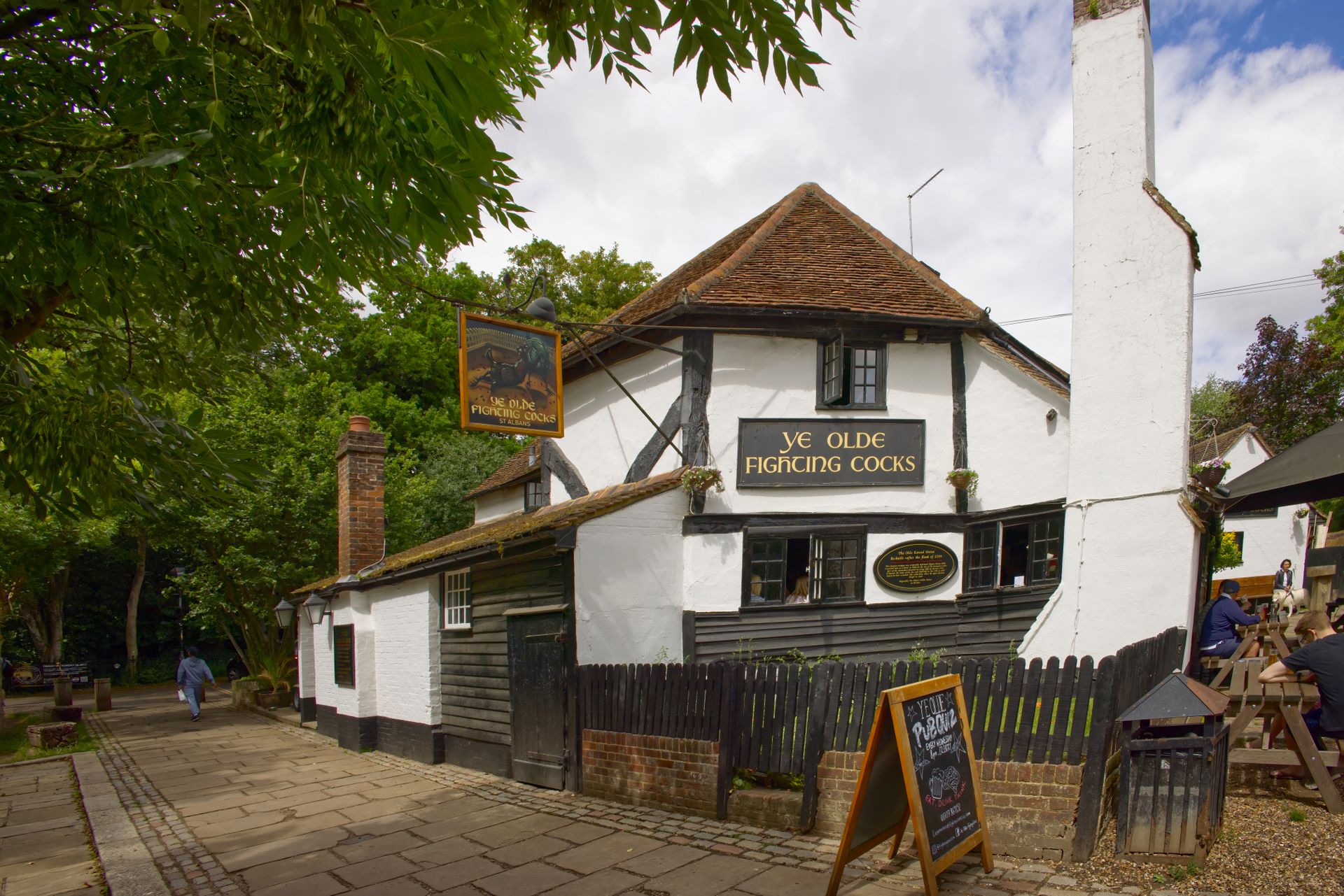 El exterior de un pub tradicional de pueblo inglés fotografiado a la luz del día.