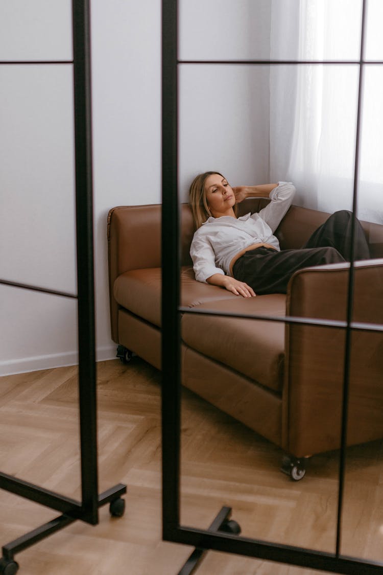 Woman Lying Down On Sofa In Room