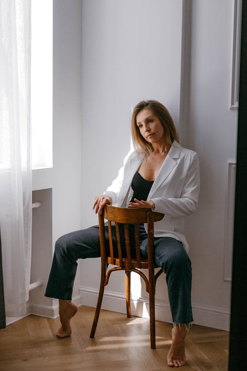 Woman in White Jacket Posing on Chair