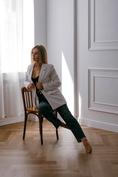 Woman in White Jacket Posing on Chair