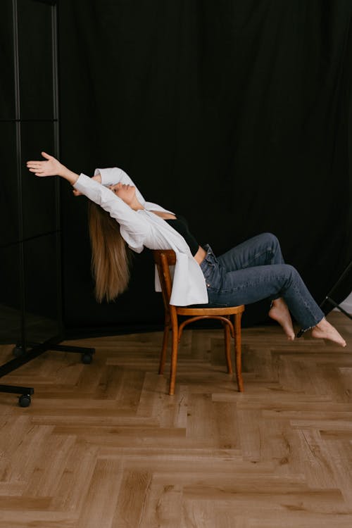Foto profissional grátis de braços levantados, cadeira, camisa branca
