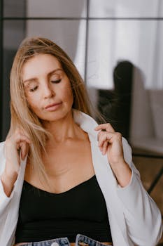 Elegant portrait of a woman wearing a white jacket with a peaceful expression.