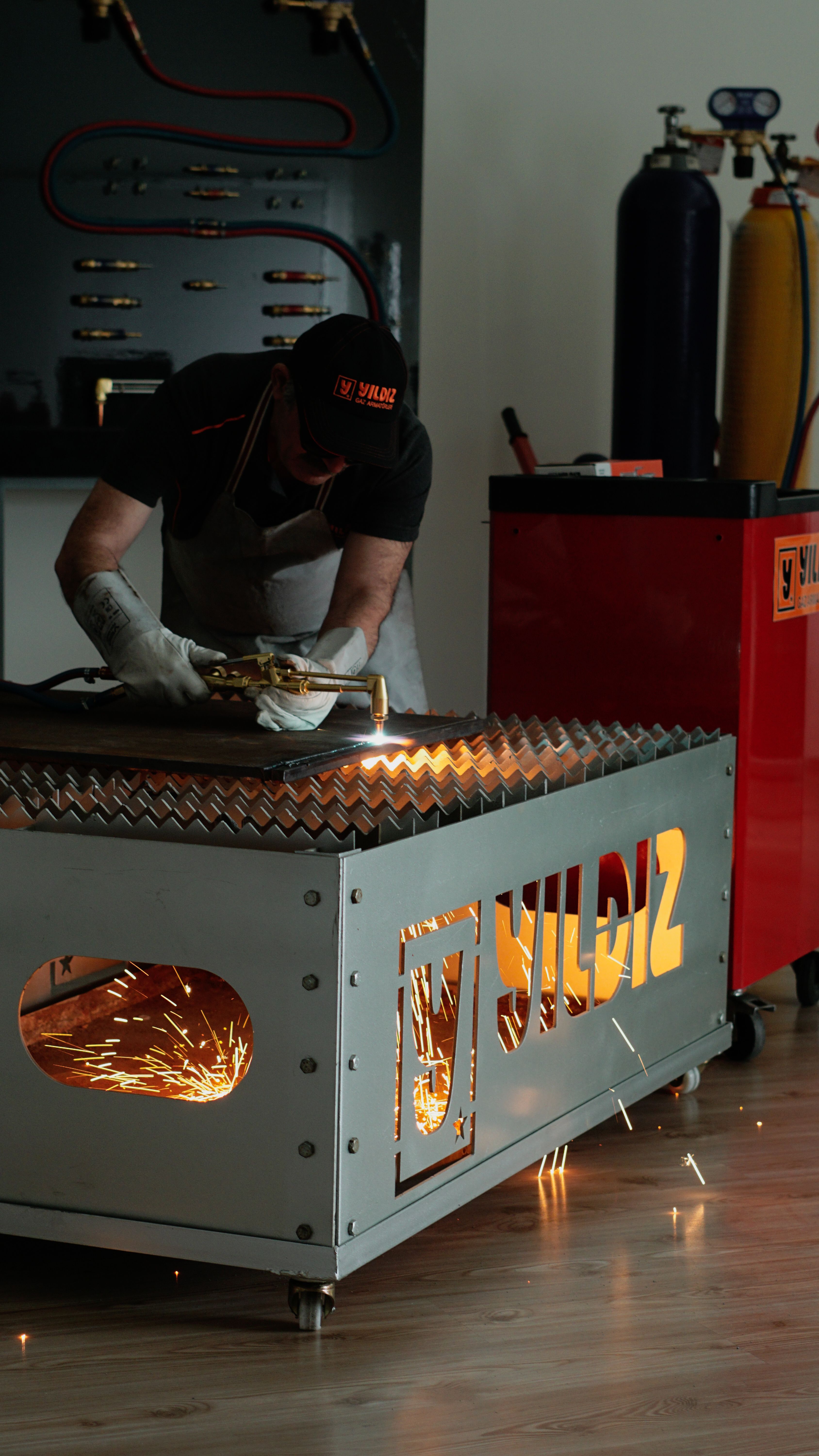 Close-up of a worker producing sparks while cutting metal in an industrial workshop.
