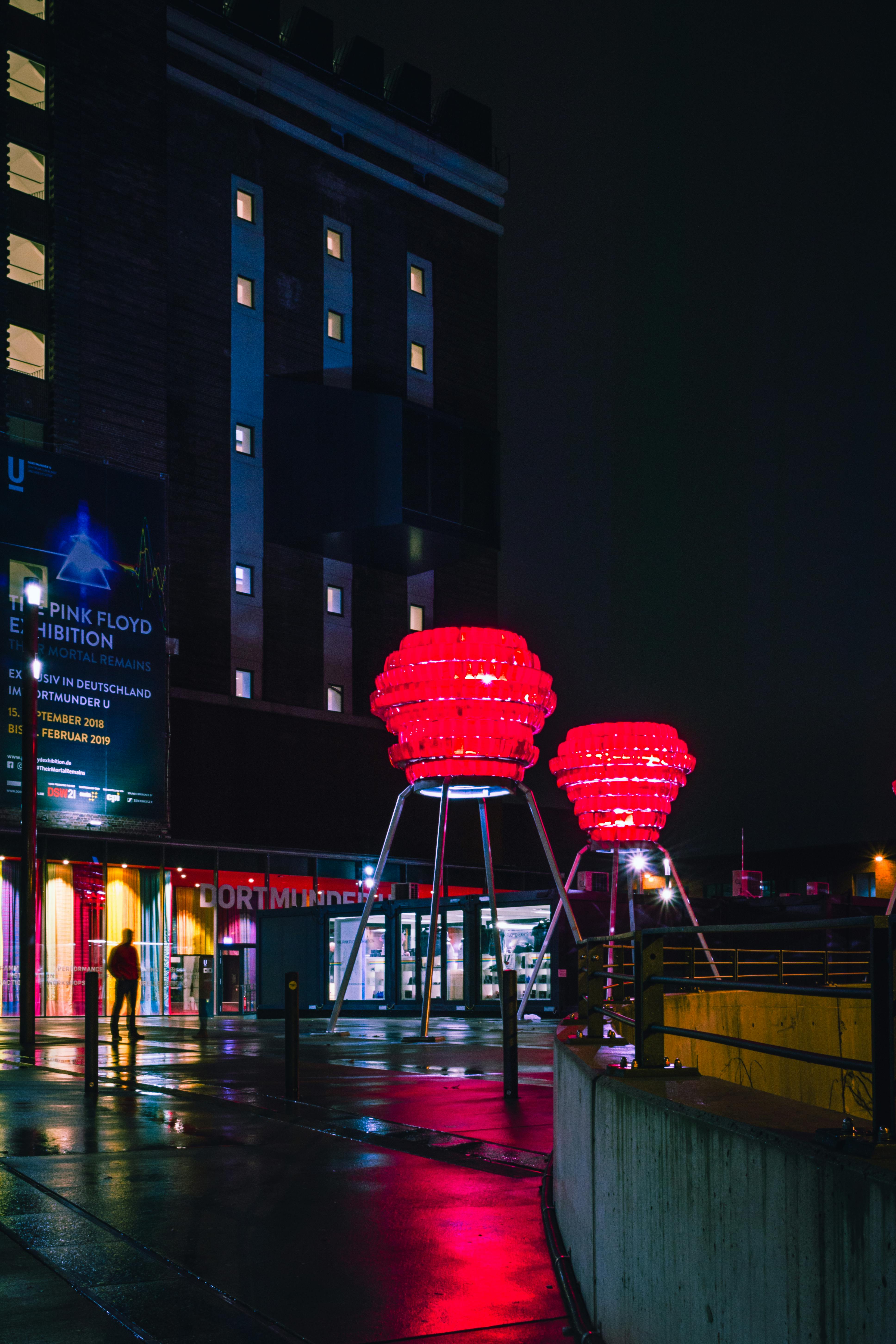 在黑暗背景的映衬下，发光的红色装置点亮了引人注目的城市夜晚