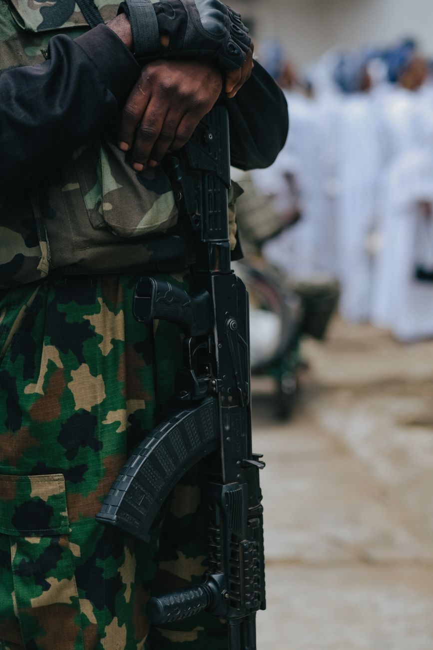 Een soldaat in camouflage-uniform met een vuurwapen, dat militaire uitrusting toont.