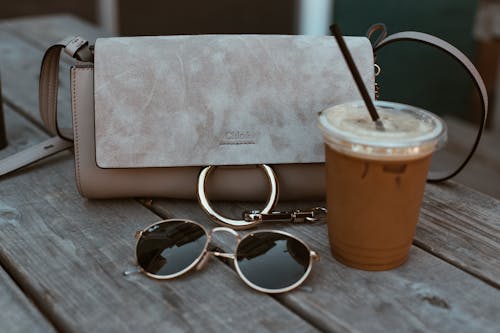Leather Crossbody Bag Beside Drink And Sunglasses