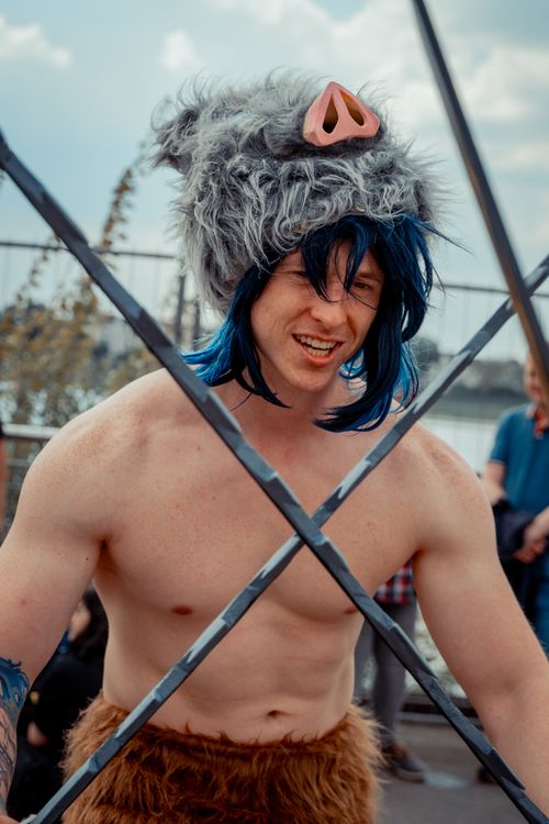 Free Man in creative cosplay with animal hat and swords at Düsseldorf event, showcasing costume culture. Stock Photo