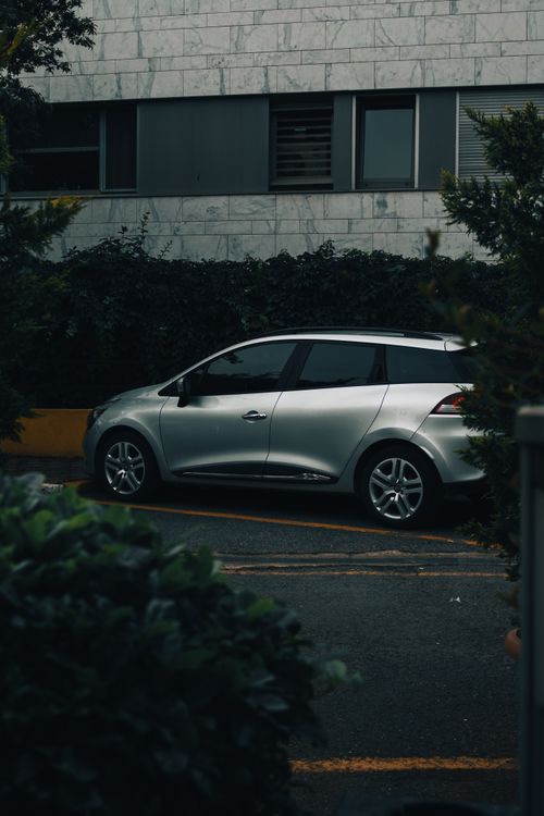 Free A silver Renault Clio parked by a modern building in İstanbul's urban setting. Stock Photo